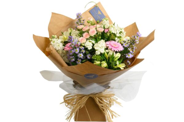 A gift-wrapped bouquet of pastel-toned flowers